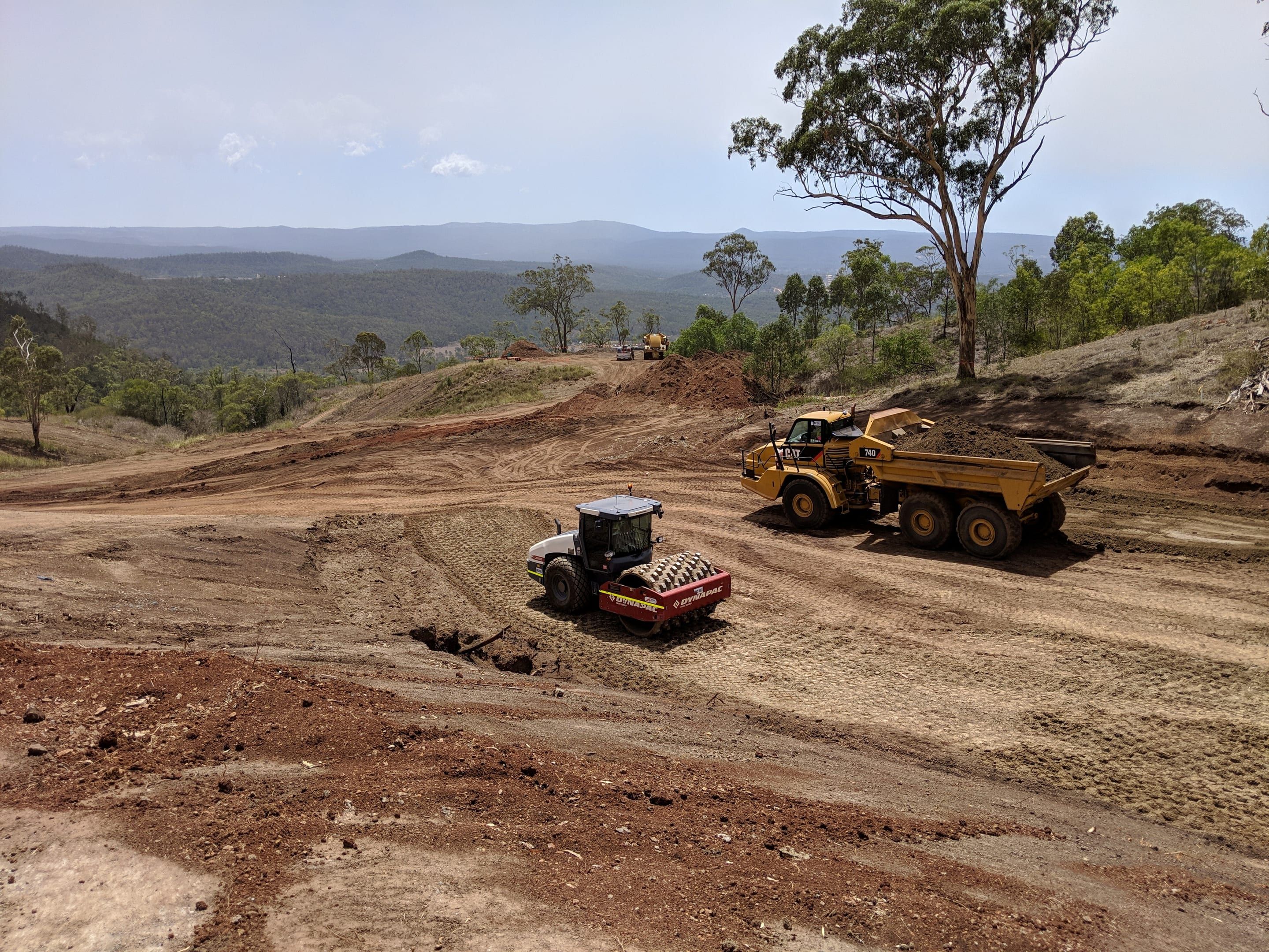 Padfoot roller and articulated dump truck on bulk earthworks for a subdivision